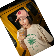Creator in a cap sipping an iced coffee