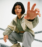 Creator crouching with a hand toward the camera